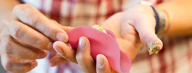Mani di Simona che chiudono un raviolo "culurgiones" rosa